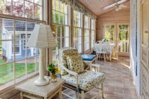 A sunroom home addition with lots of windows